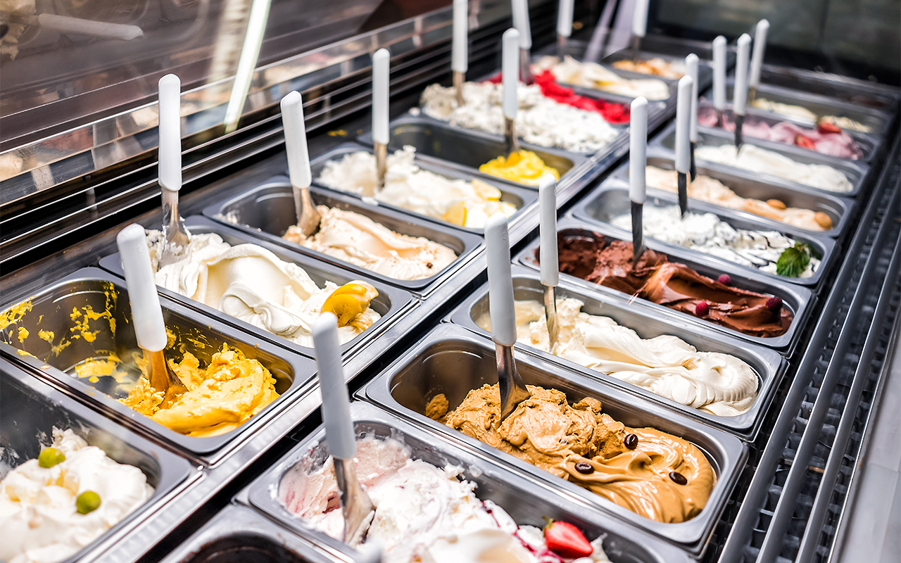 An assortment of frozen gelato and custard that can be found in a frozen yogurt shop for sale.